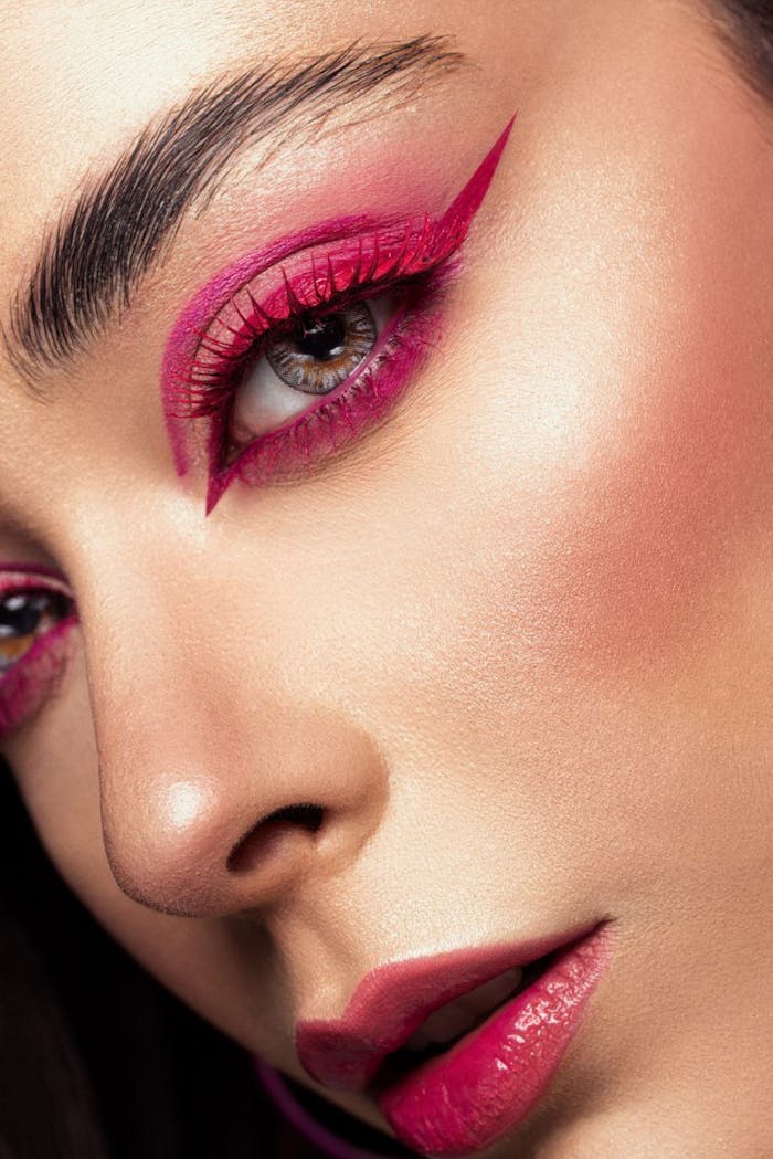 services-04 Close-up of a woman's face highlighting bold pink eyeliner and makeup in an artistic portrait.