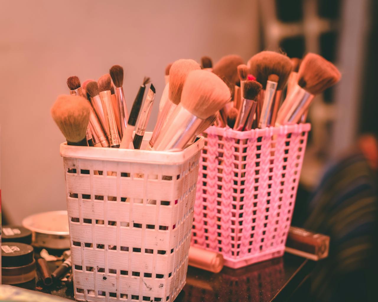services-img Collection of various makeup brushes organized neatly in pink and white holders.
