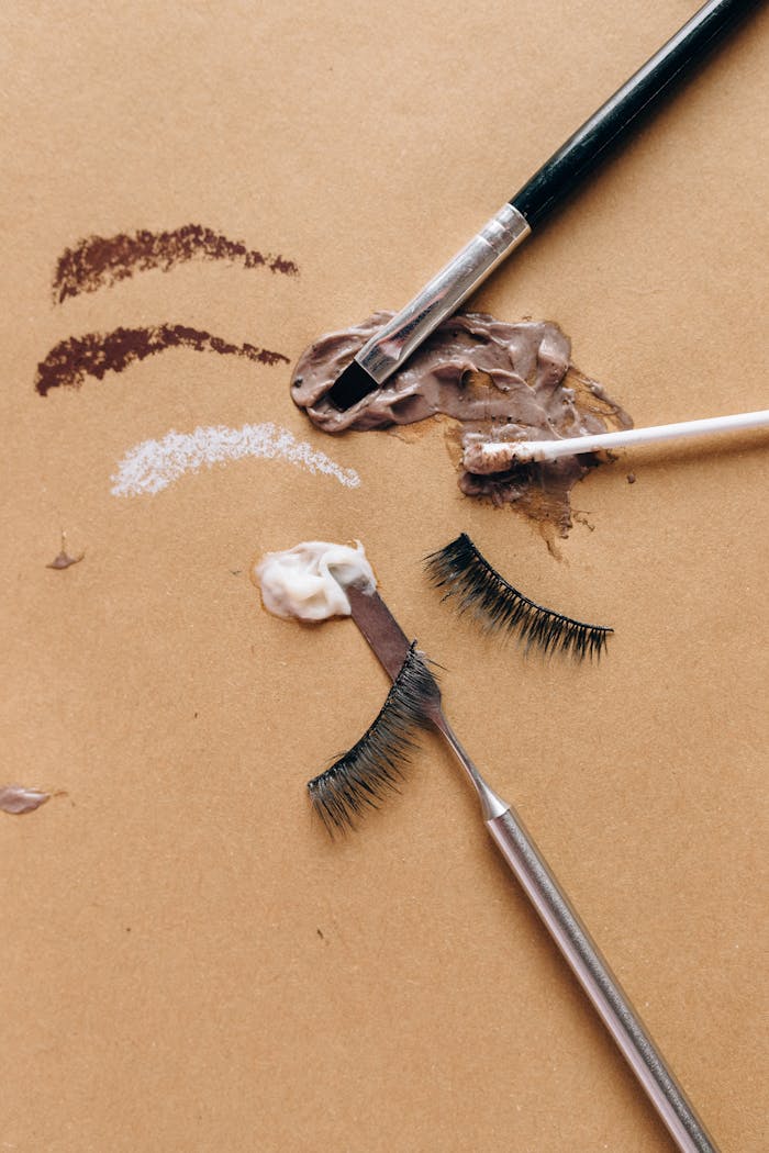 hero-img-01 Creative flat lay of makeup brushes, cosmetics, and false eyelashes for beauty concept.